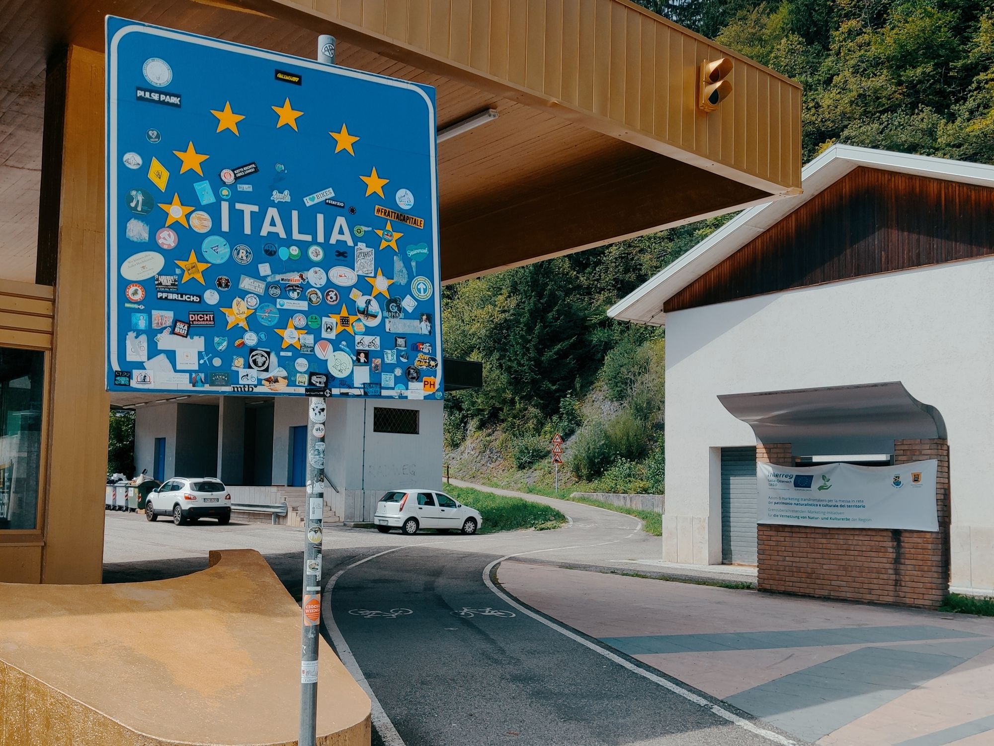 Obklejona kolarskimi wlepkami ze wszystkich stron świata tablica informująca, że wjeżdżamy na włoski odcinek Alpe Adria